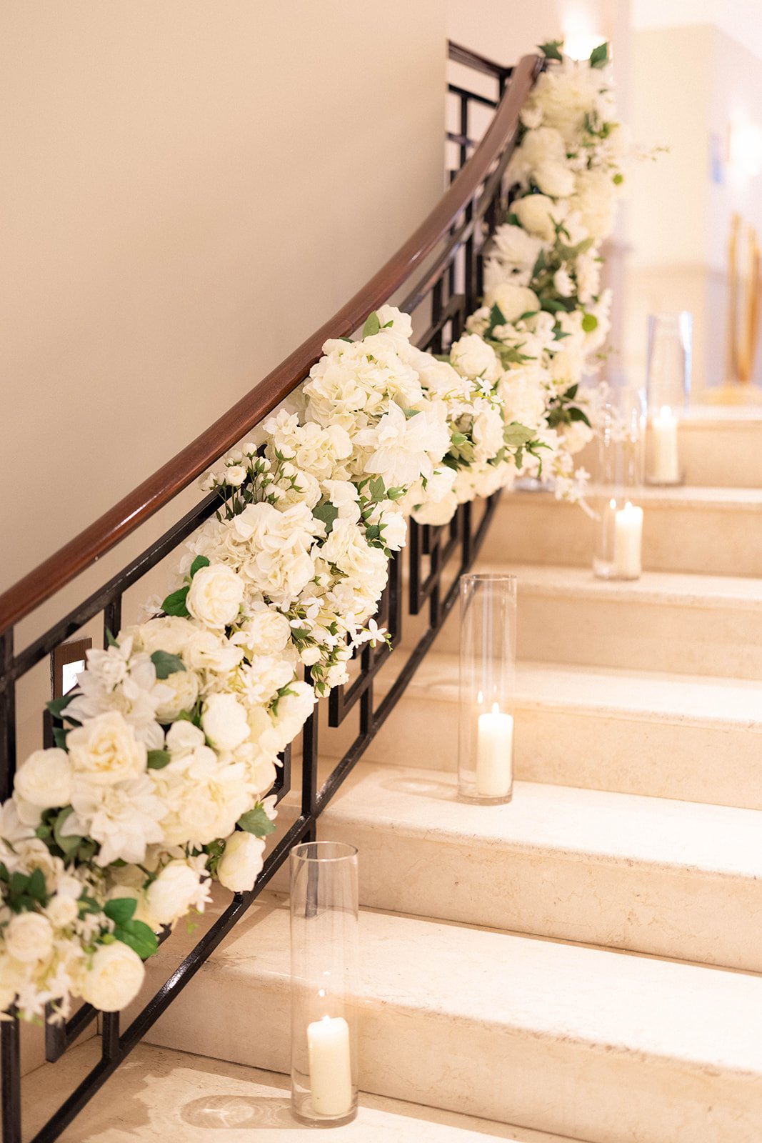 Floral staircase with hurricane lamps.jpg