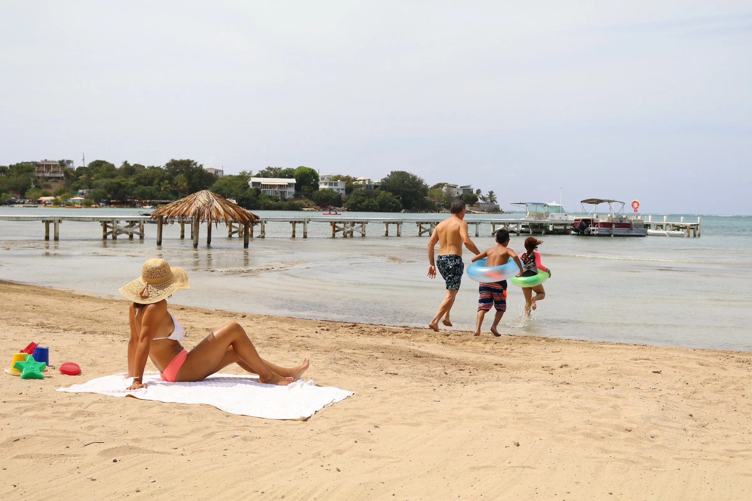 a woman watches a family going into the water in Puerto Rico 