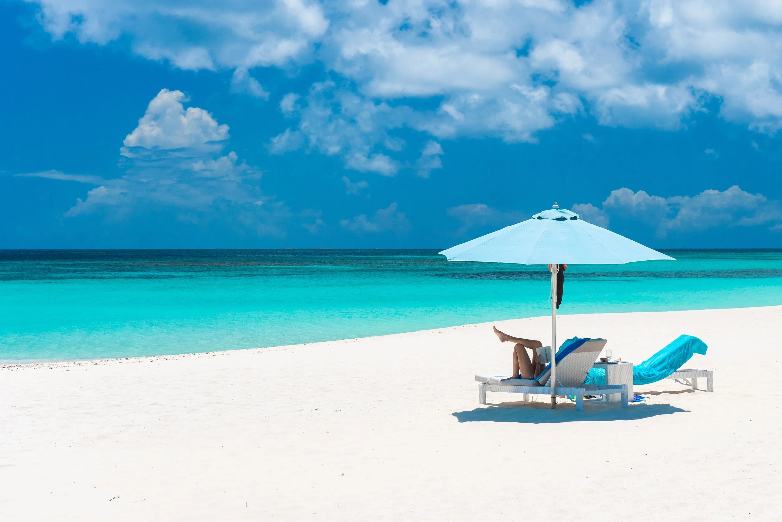 a parasol with two loungers and and the sea