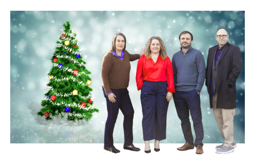 Four people standing next to a decorated Christmas tree with snowflake background.
