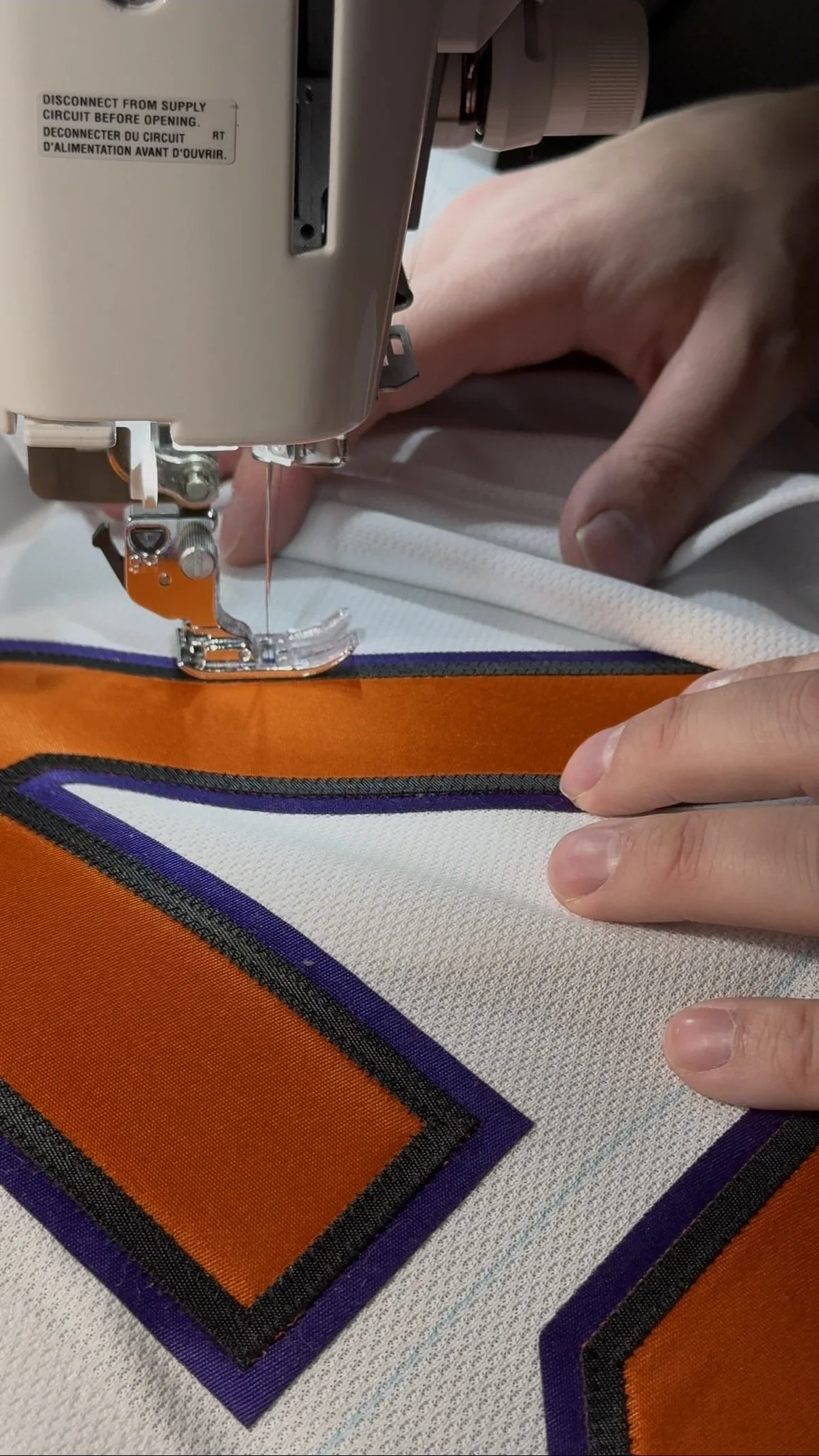 Finished wedding jersey number being permanently sewn to the jersey