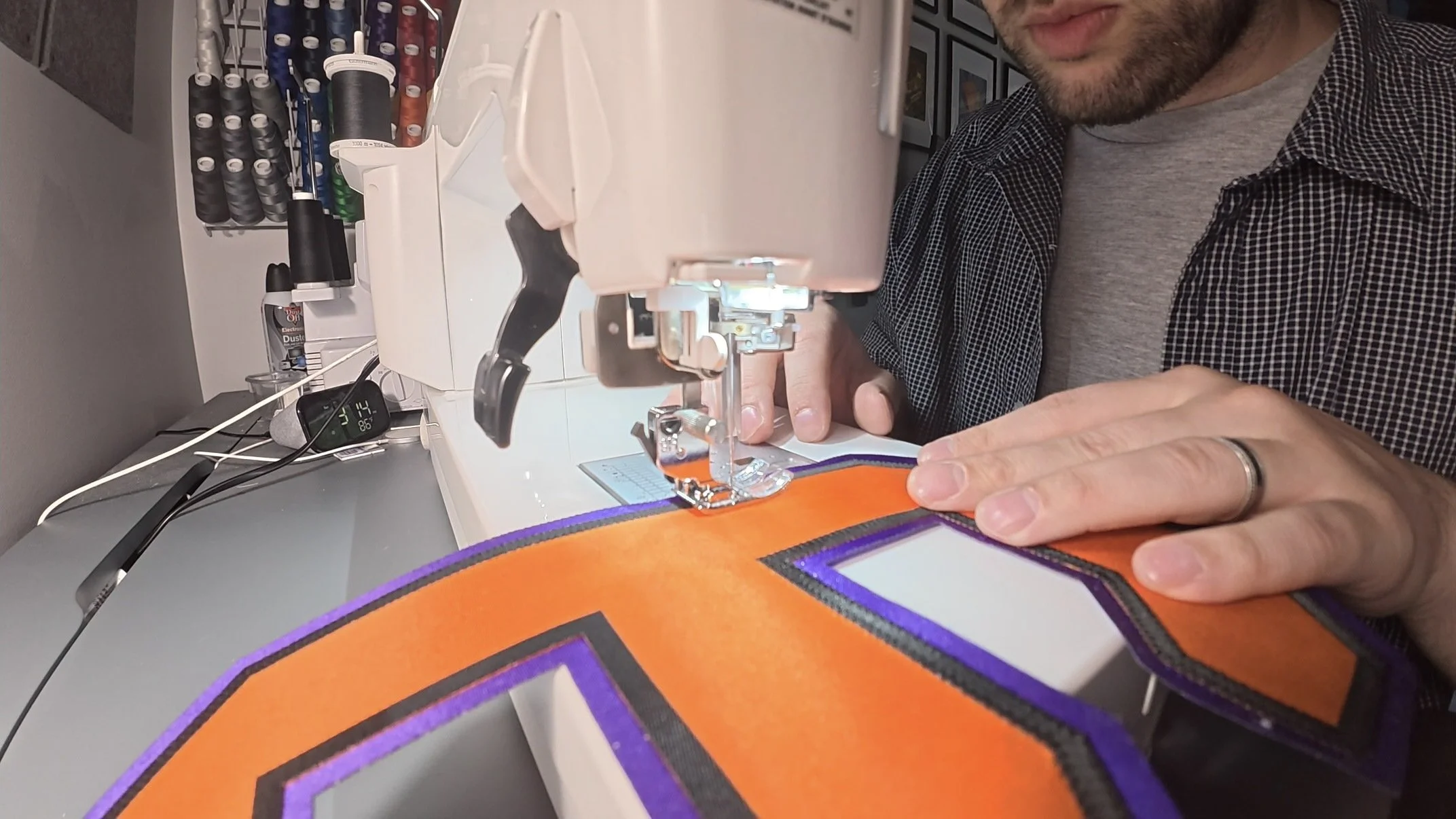 Multi-layer hockey jersey number being sewn by hand