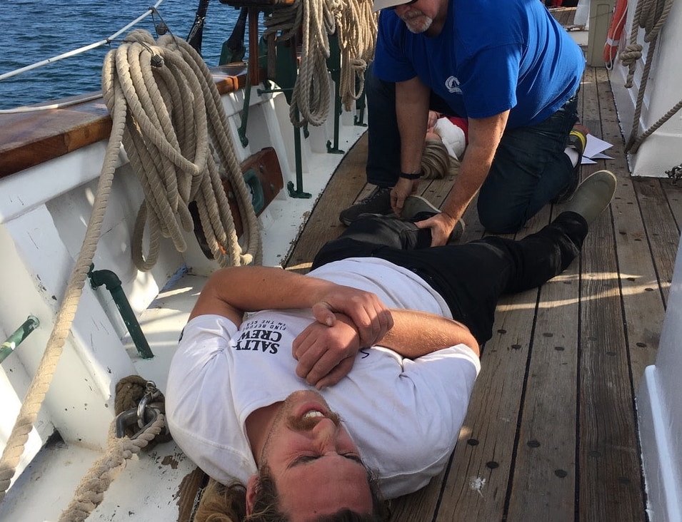   A participant practicing patient assessment skills on a fellow student acting as an injured mariner.  