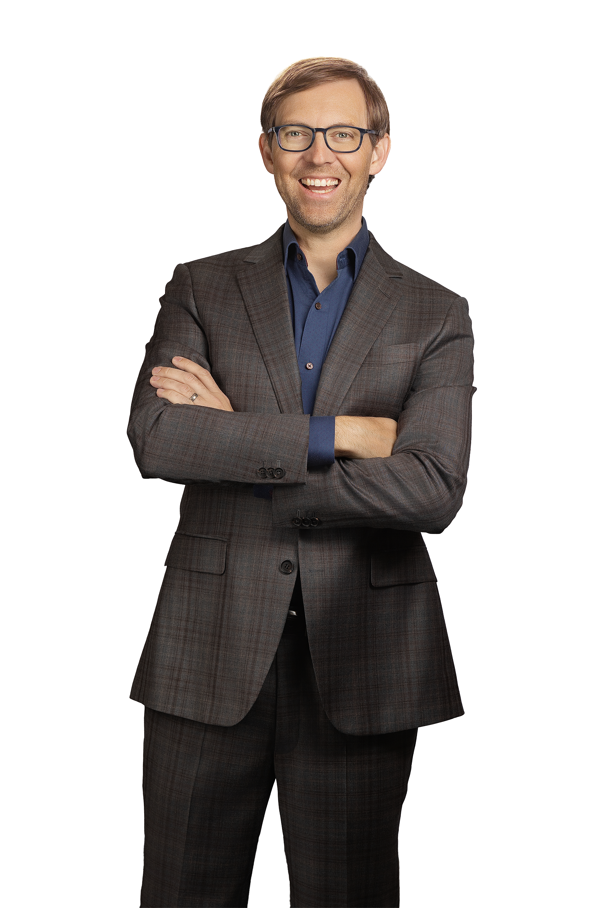 A man wearing glasses and a suit with a checkered pattern, smiling and crossing his arms.