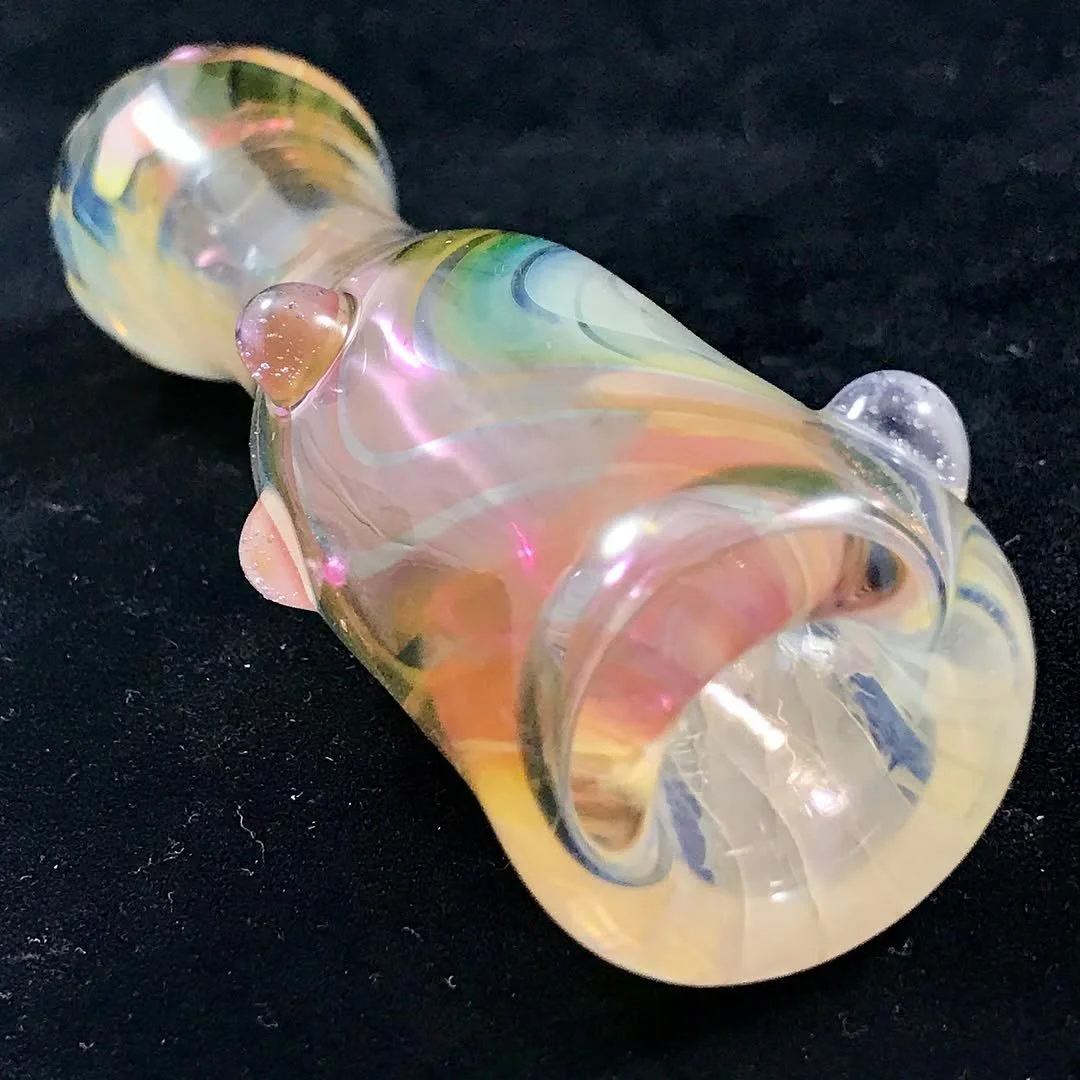 Colorful, iridescent glass pipe with swirled design, lying on a black surface.