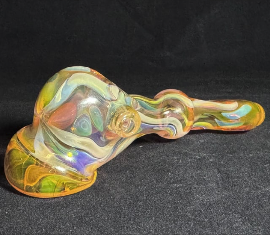 Colorful glass pipe on a black surface.