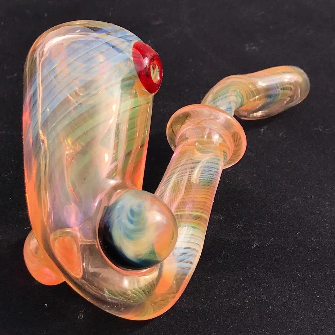 Colorful glass pipe on a black surface.