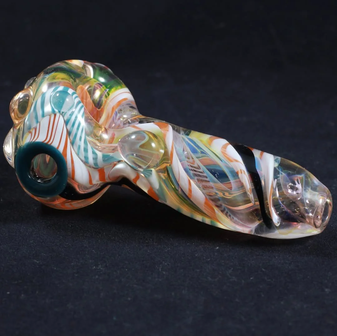 Colorful glass pipe with swirling patterns on a black background.