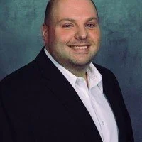 Logo with black roofing roof above the text 'Clear Skies Restoration' in bold black letters, with 'Restoration' in white text on a black background strip.