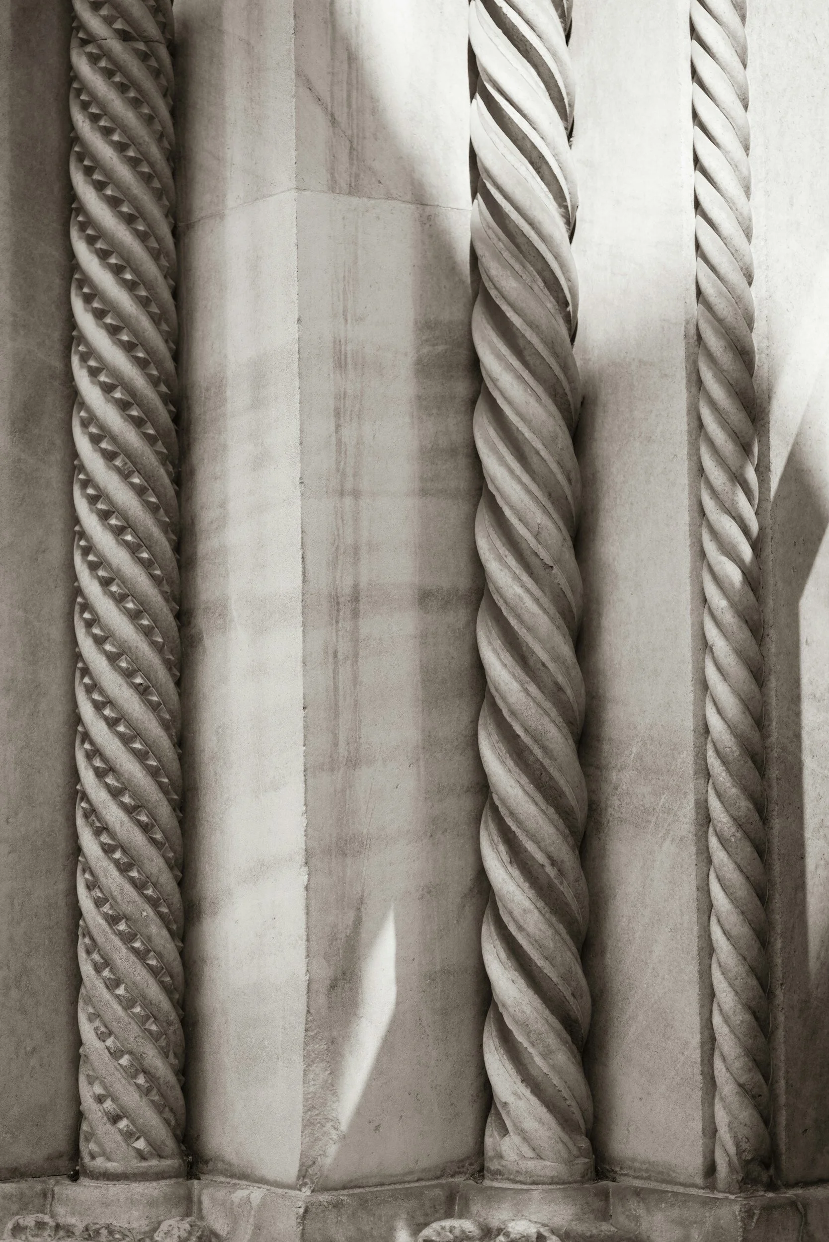 Close-up of intricately carved twisted columns on a stone building.