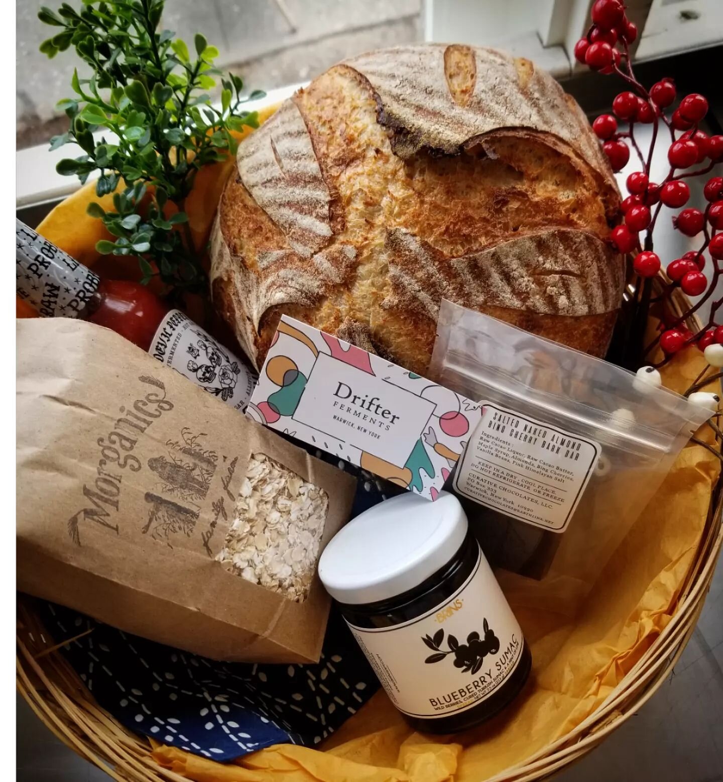 Yule gift baskets are now available daily until Christmas Eve at noon. This sample basket is $60 and includes our oat porridge einkorn sourdough, a jar of Blueberry Sumac @brinsjam, @poordevilpepperco Smoke Shifter, @curativechocolates pomegranate ca