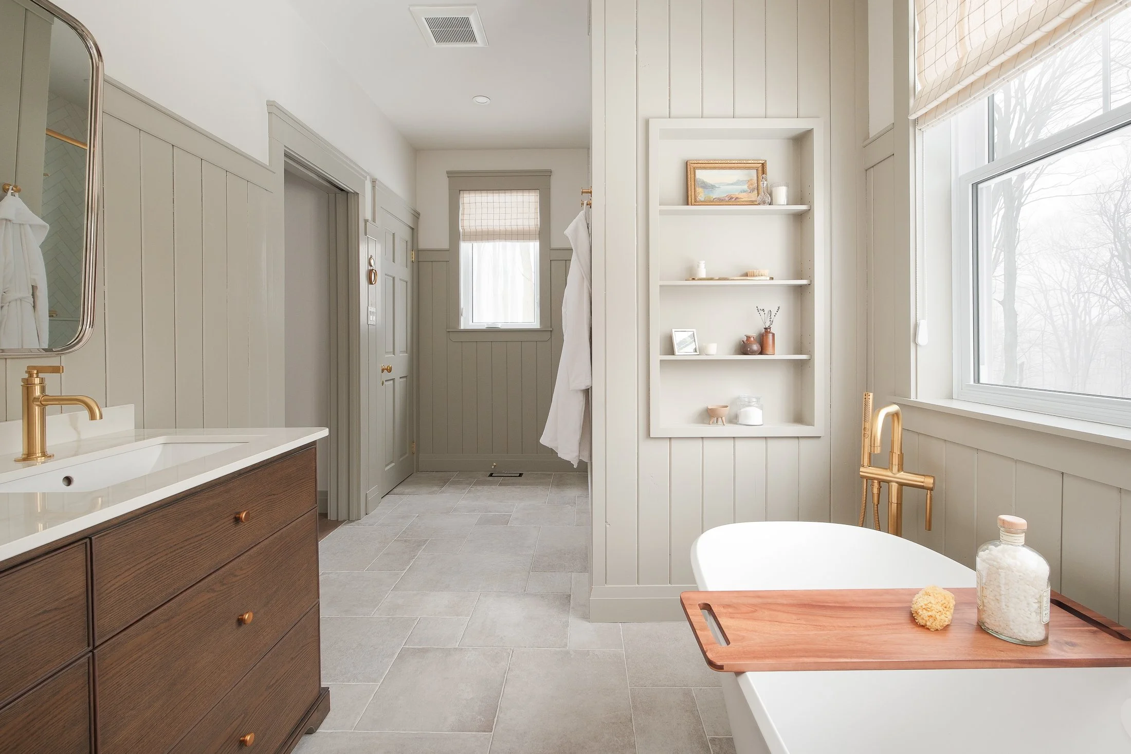 Completed bathroom renovation with wood-grain vanity, gold fixtures, and custom built-in storage, Wellington House Turnkey service, Kawartha Lakes