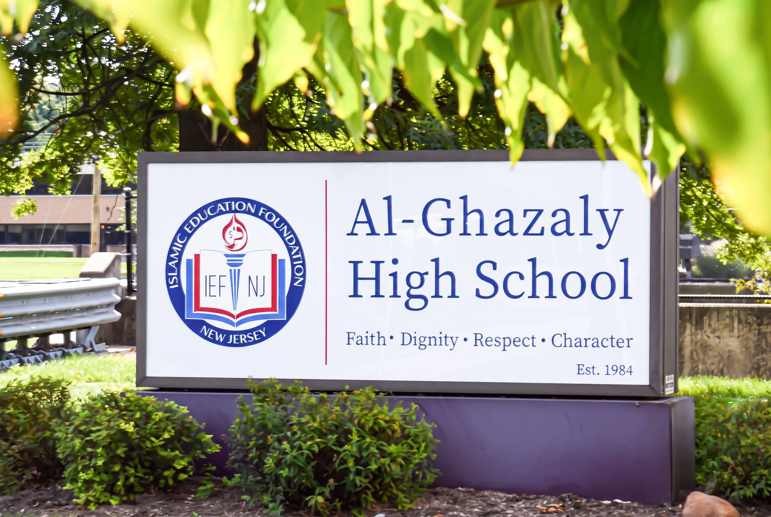 Sign for Al-Ghazaly High School with the school logo and motto.