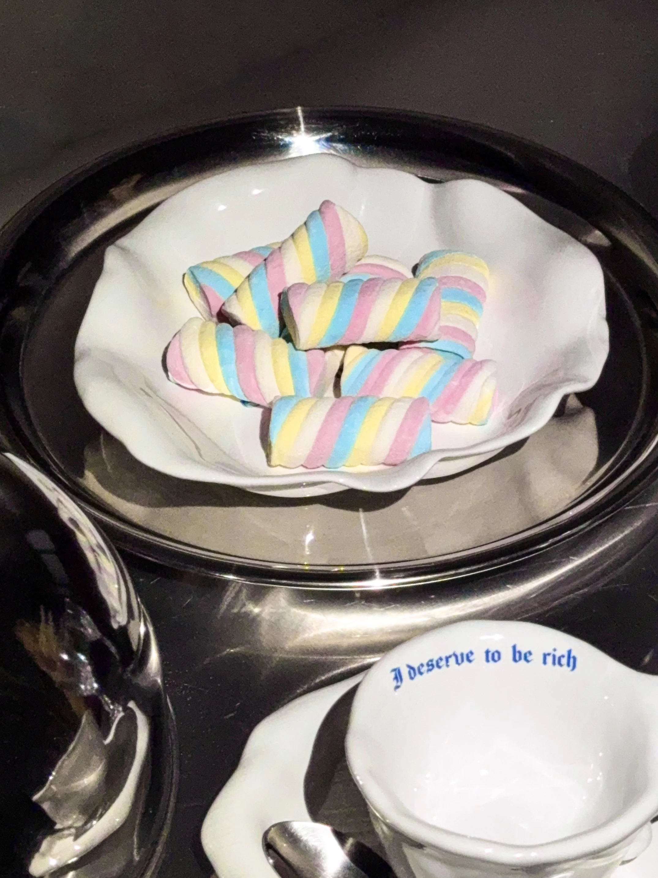 Colorful striped marshmallow candies on a white dish
