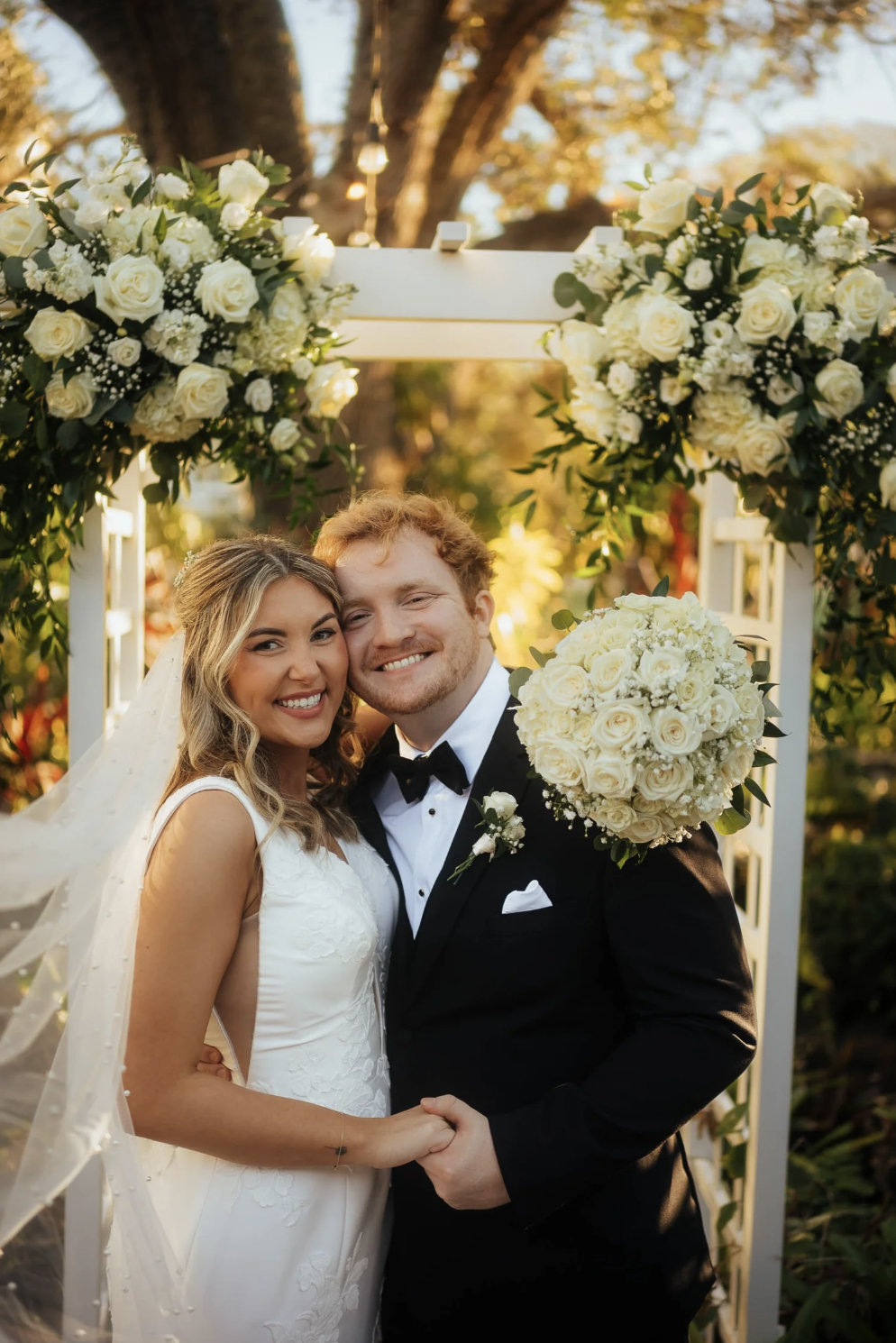 Bride and groom wedding portrait under wedding arch at Sarasota Garden club in Sarasota, Florida
