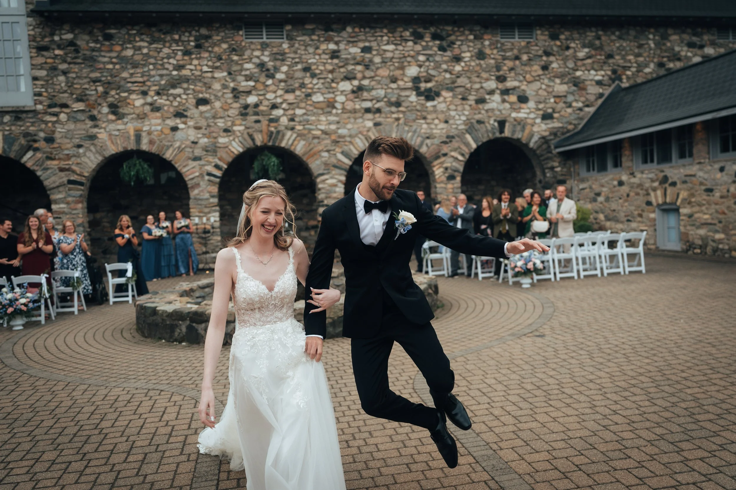 Castle Farms, Charlevoix wedding documentary style wedding photo candid of couple post ceremony, groom is jumping with joy.