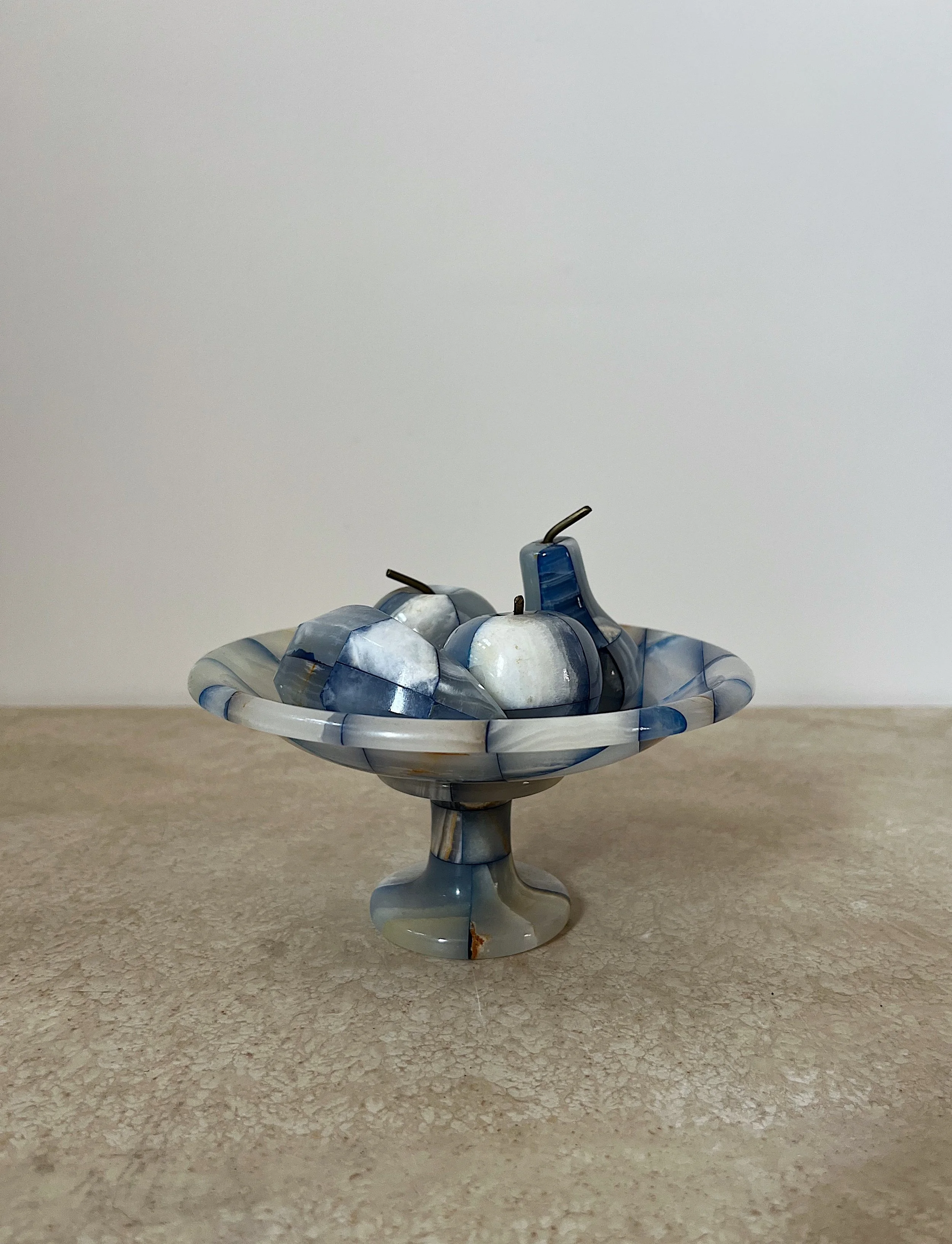 Decorative stone fruit in a matching stone bowl on a table