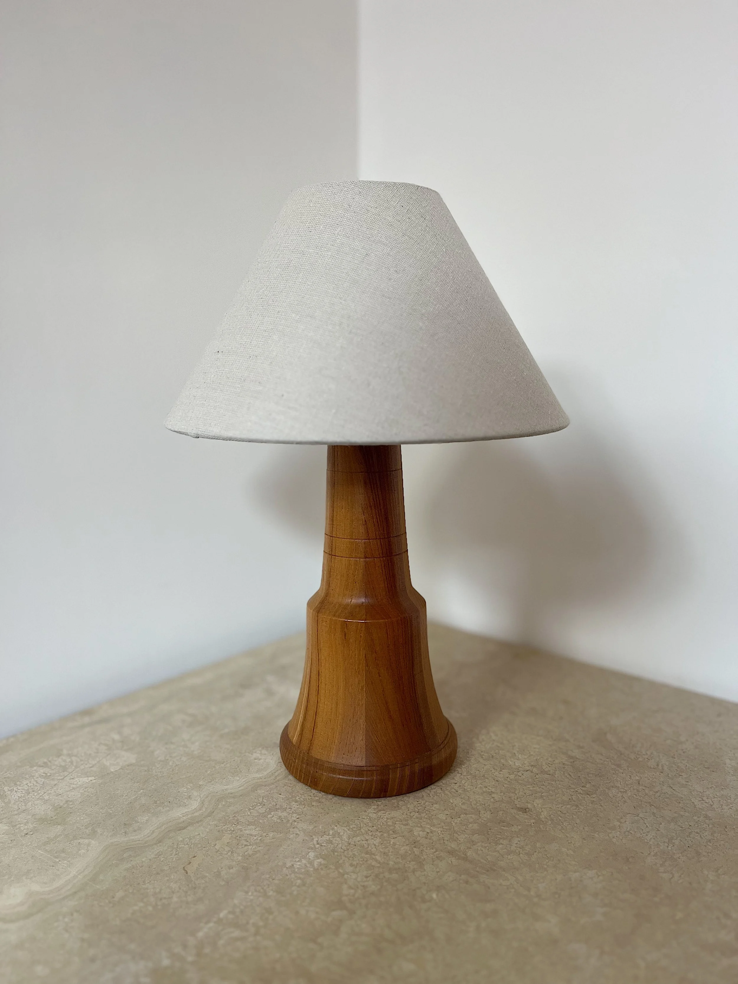Wooden lamp with a beige shade on a table