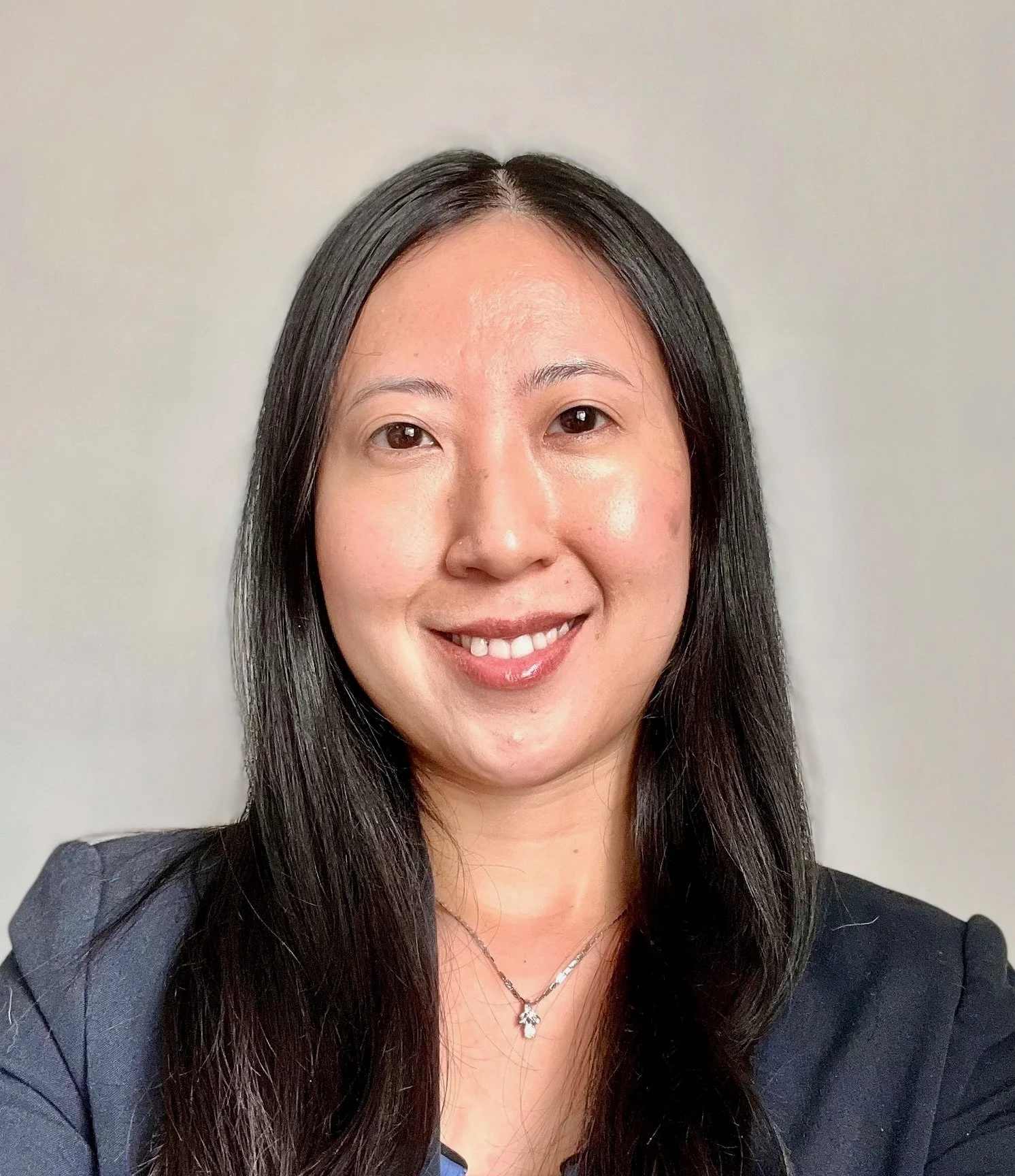 Portrait of Dr. May Liu, smiling with a neutral background