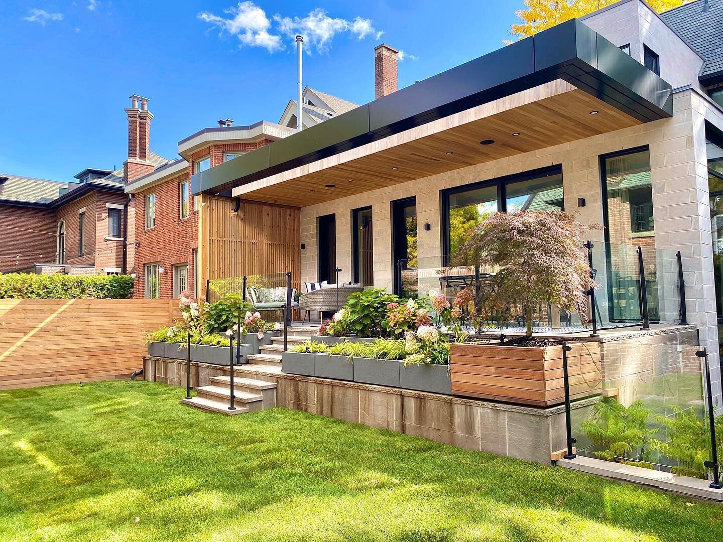 Design + build backyard project with cedar privacy screen, cedar staggered fence, custom insulated planter boxes and built in Ipe planter box with a cascading waterfall Japanese maple.