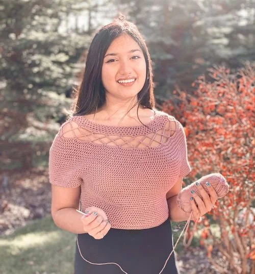 Shelle Agrawal of Chain Two Crochet in a pink crochet top with lattice neckline details