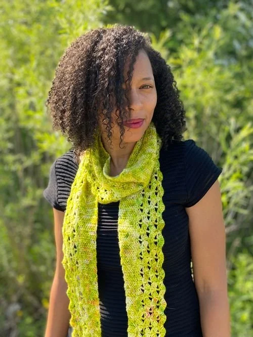 Kim Davidson of KMDCrochet in a black tee and a lime green lacy scarf outdoors