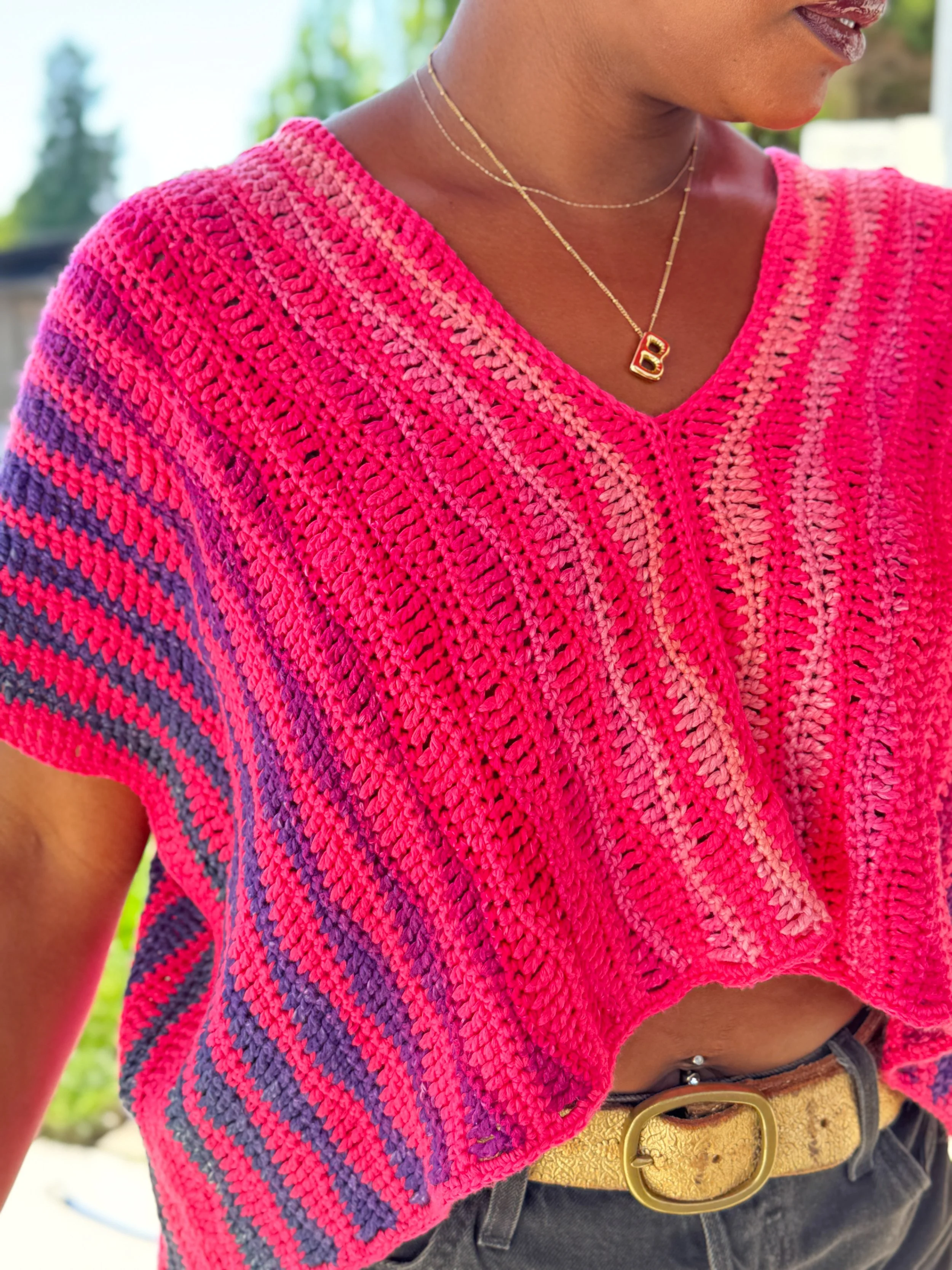 Pink and orange oversized crochet crop tee made with DK weight yarn, shown in a boxy fit with simple stitch texture and warm-weather styling.