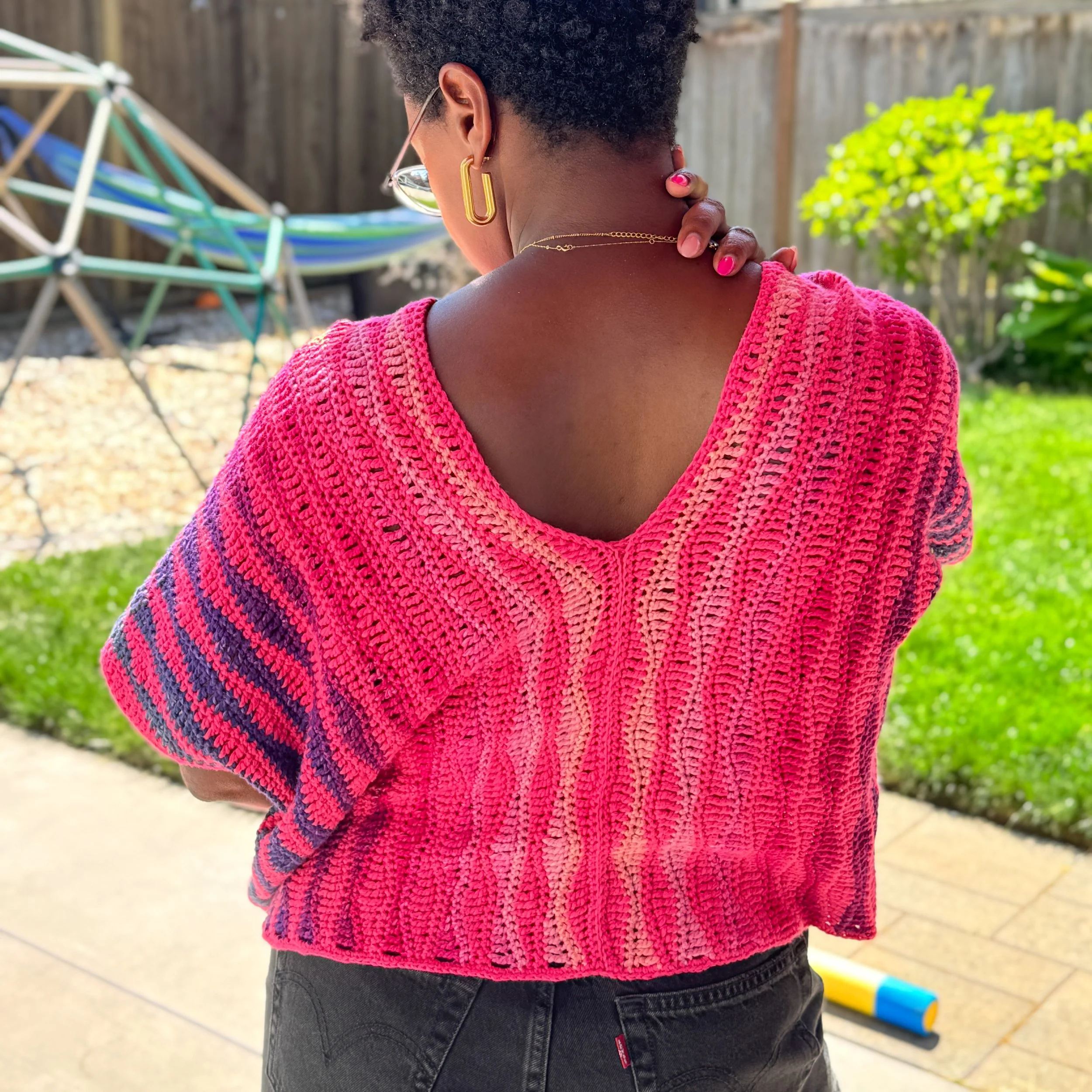 Pink and orange oversized crochet crop tee made with DK weight yarn, shown in a boxy fit with simple stitch texture and warm-weather styling.
