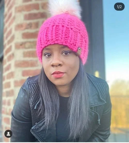 Crystal Green of Tipsyhook in a hot pink knit beanie with a faux fur pom-pom