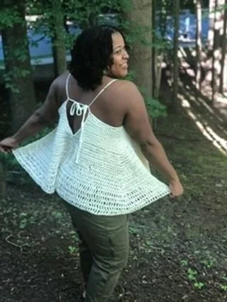 Tameika Reynaud of MeikaRay,INC in a white flowy crochet top with a tie back, outdoors