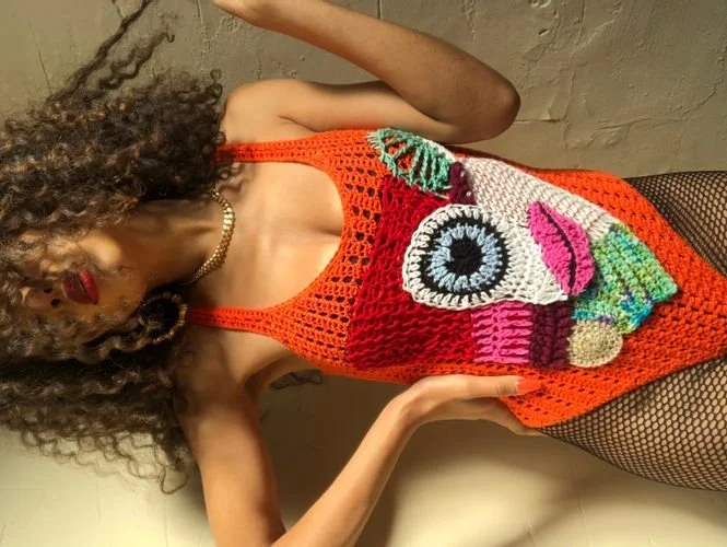 Bretony Mcgee of BreSellsSeaShells in an orange crochet top with an appliqué face design