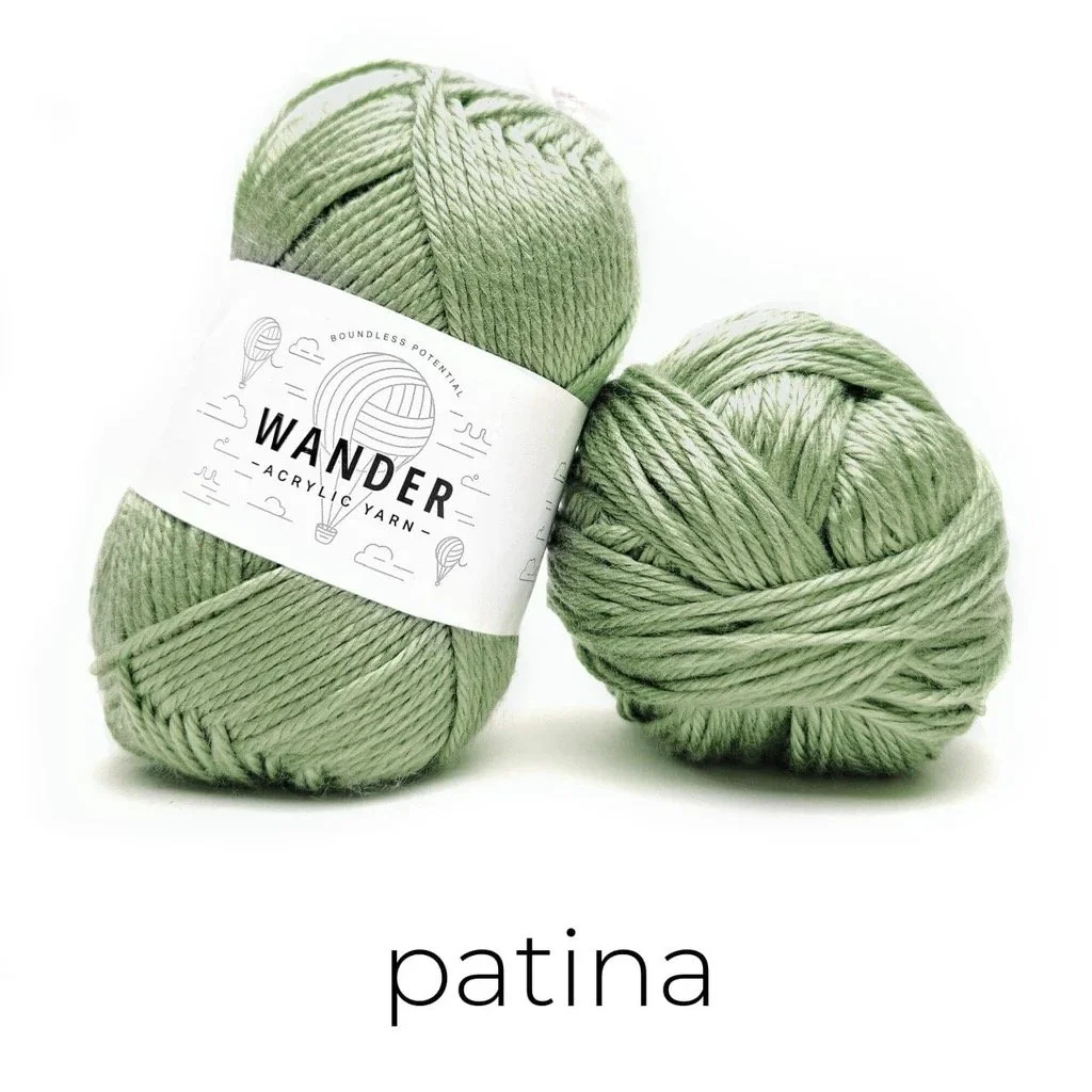 Skeins of Furls Wander yarn in the Patina colorway, a worsted weight yarn used for the Easy Drape Bandana.