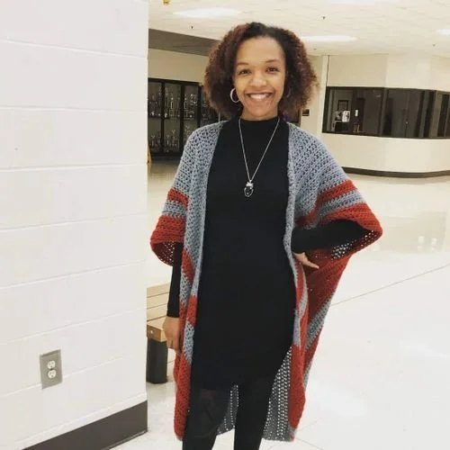 Natasha Stewart of Crochay Chay All Day in a long gray crochet cardigan with red and black stripes