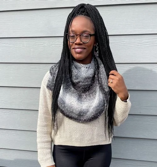 Brittany Garber of KnotBadBritt in a cream sweater and a black and gray gradient crochet cowl
