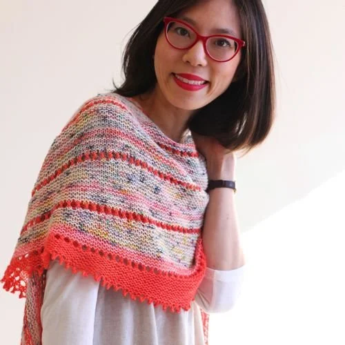 Stephanie Sinclair of Edible Thoughts Makes in red glasses and a striped shawl with a coral lace edge