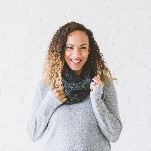 Kelsie Weeks of Crafting for Weeks smiling in a gray sweater and a dark speckled cowl