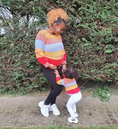 Victoria Barrett of In The Stitch With Vix and a child in matching rainbow striped knit sweaters