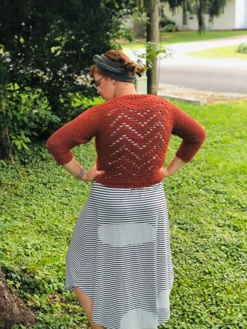 Steph McDaniel of Knot More Yarn in a rust lace-back sweater, seen from behind