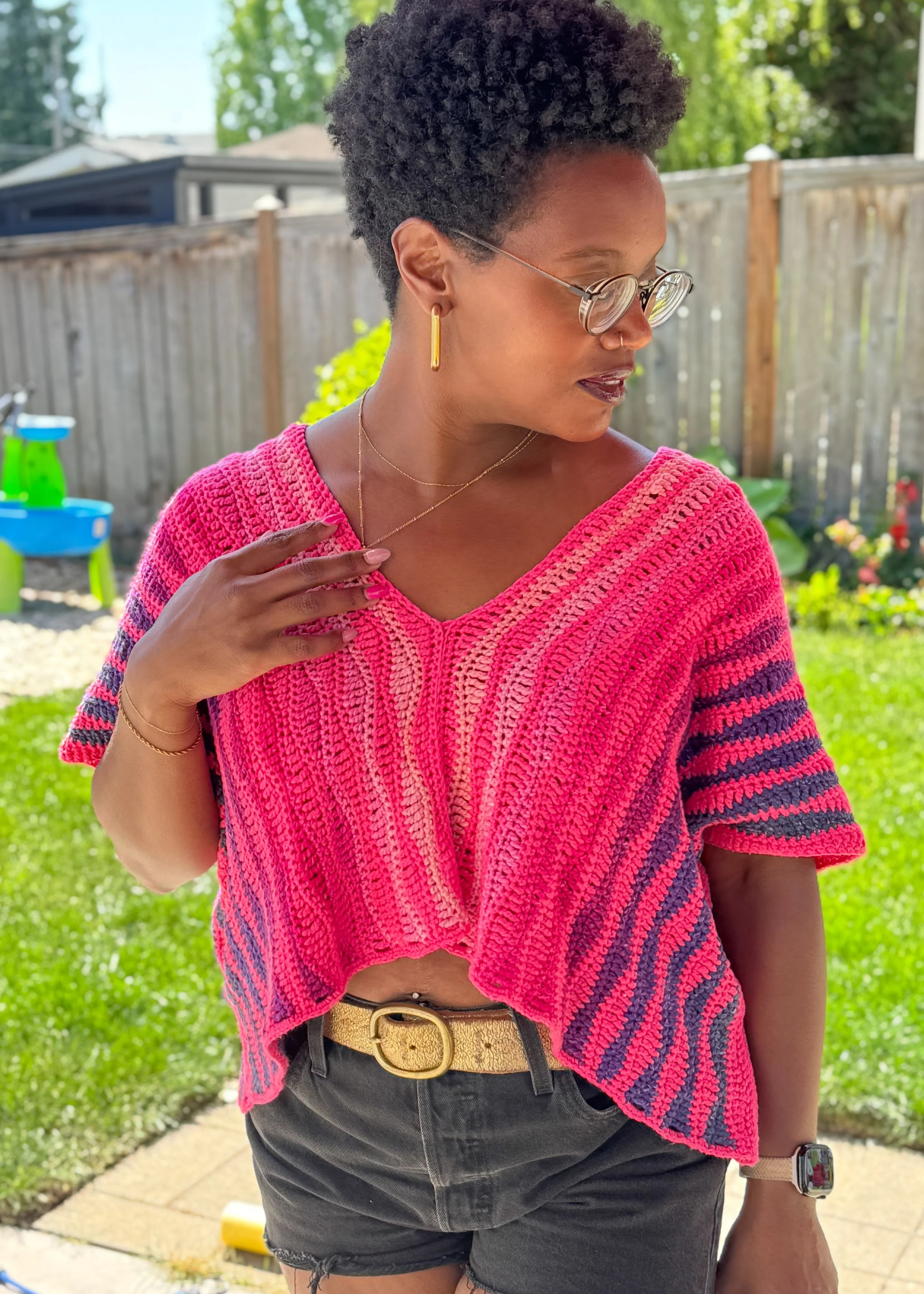 Pink and orange oversized crochet crop tee made with DK weight yarn, shown in a boxy fit with simple stitch texture and warm-weather styling.