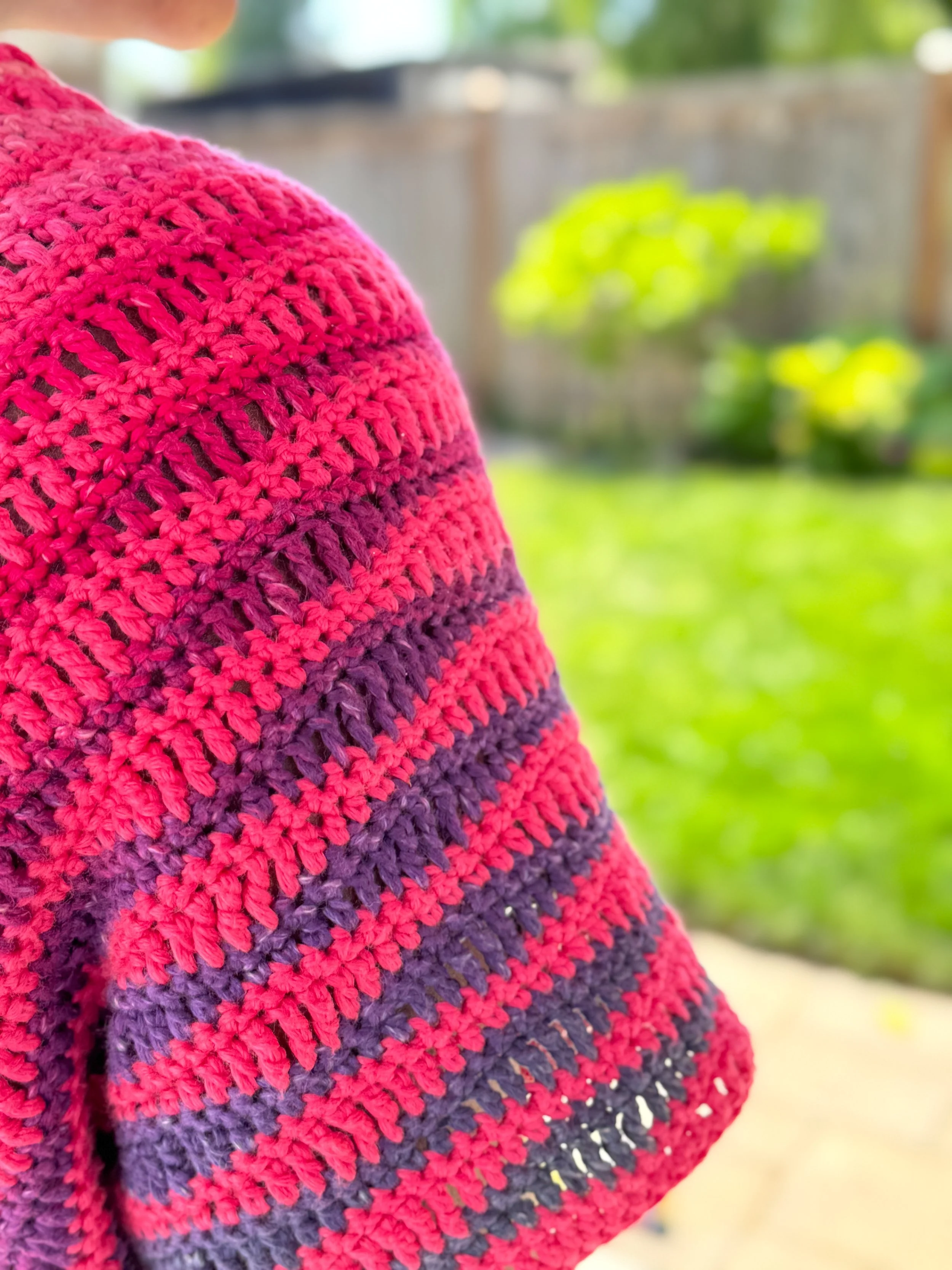 Pink and orange oversized crochet crop tee made with DK weight yarn, shown in a boxy fit with simple stitch texture and warm-weather styling.