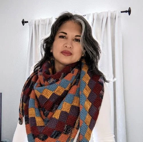 Jennifer Wijangco wearing a checkered crochet scarf in rust, gold, blue and plum