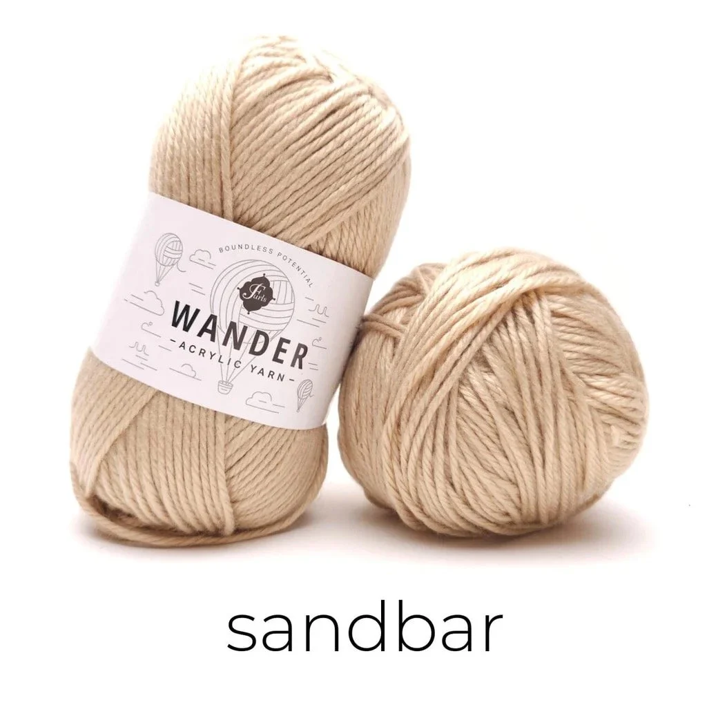 Two skeins of Furls Wander yarn in Sandbar, a light tan worsted weight yarn used for the Easy Drape Bandana.
