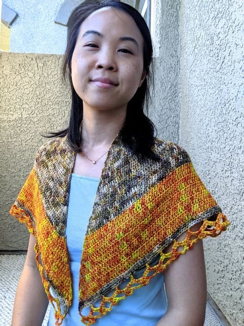 Alice Chang wearing a gold and gray crochet shawl over a light blue top