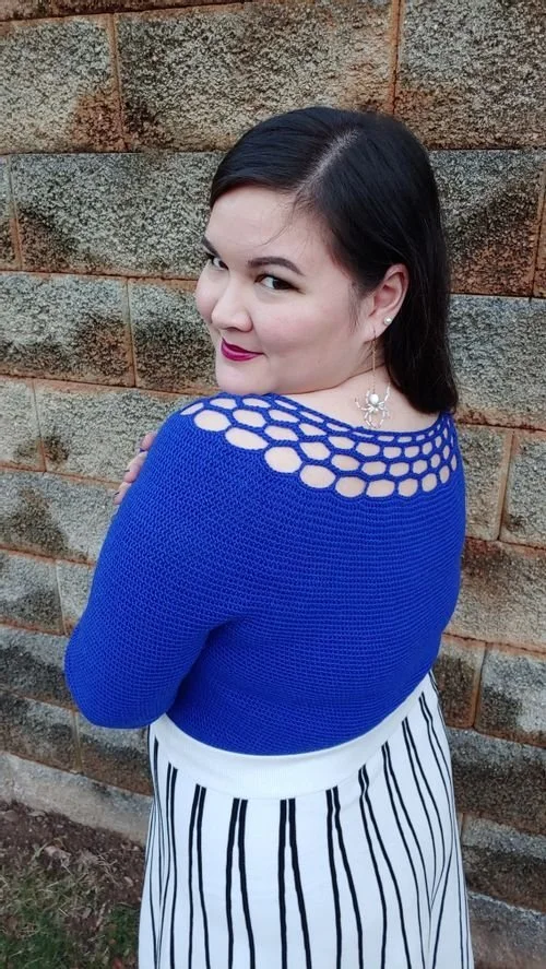 Emily Ansusinha of EmilyProcraftinates in a cobalt blue knit sweater with an open-work yoke