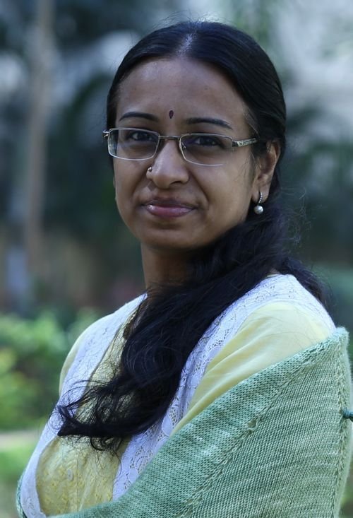Jayalakshmi MH of Apoorva Designs wearing a sage green knit wrap outdoors