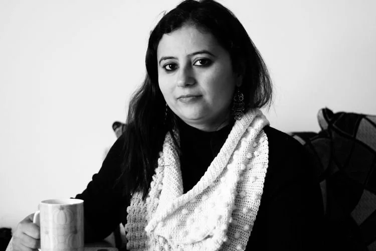 Sunaina Kapoor of Station Owl in a white bobble-stitch cowl, in black and white