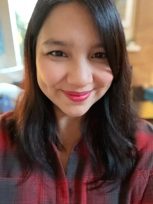 Sarah Klippel smiling in a red plaid shirt