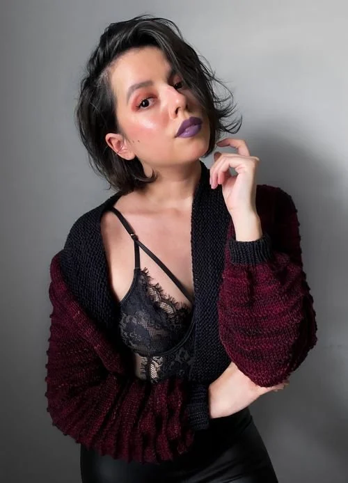 Daniella Hua of Odd Knots + Threads in a black and burgundy knit cardigan over a lace top
