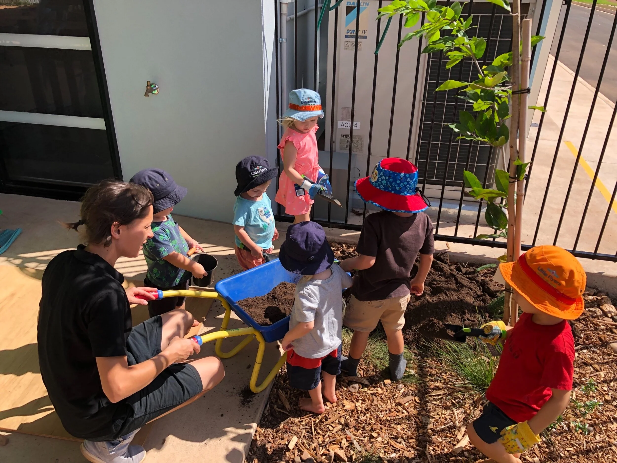 children playing with teacher in sandpit.jpg