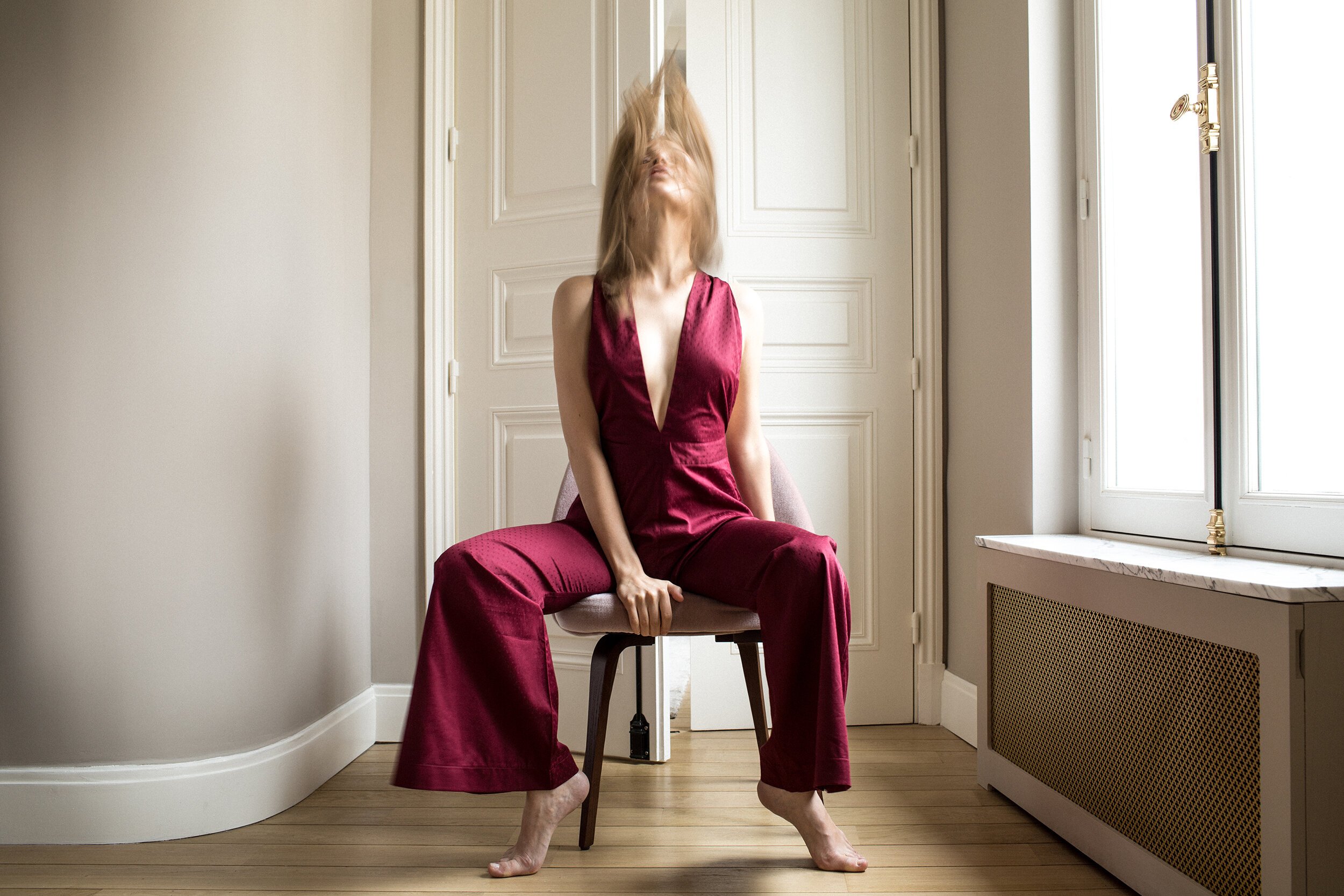 motoin blur parisian apartment model blonde hair whip artistic dark red jumpsuit.jpg